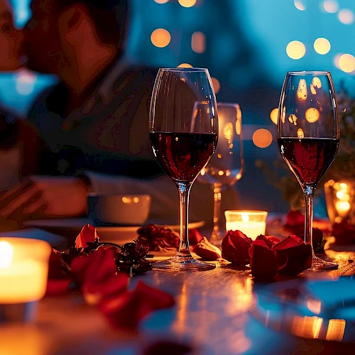 A romantic dinner scene with wine glasses, candles, rose petals, and blurred couple in the background, warm evening ambiance ending with a period.